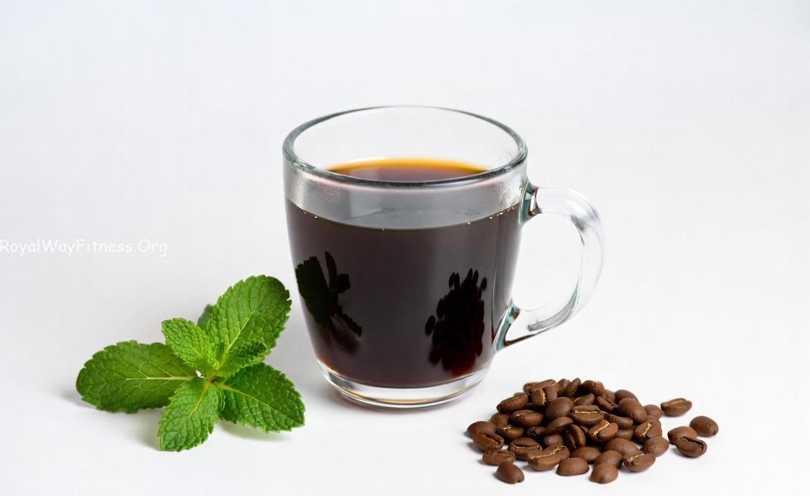 A cup of coffee on an office desk next to a laptop representing mental focus and alertness